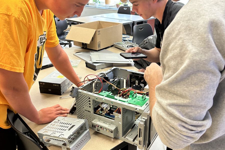South Fayette cybersecurity students examining motherboard and components inside an opened computer tower